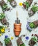 Gardening setting with terracotta plant pots, shovel and garden flowers with earth and roots on  pale green background. Repotting