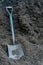 A Gardening Shovel in a Large Pile of Black Mulch