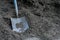 A Gardening Shovel in a Large Pile of Black Mulch
