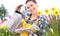 Gardening smiling woman with watering can narcissus flowerbed