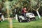 Gardening with worker using a ride on tractor, mower for cutting grass