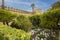 Gardens at the Alcazar de los Reyes Cristianos in Cordoba, Spain. Part of a stone wall and a tower surrounded by fruit