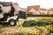 Gardner using lawn tractor and cutting grass in garden during weekend time