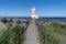 Gardur Old Lighthouse in Iceland, white and red striped light house on a sunny day