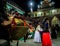 Garhwali locals in vibrant traditional attire dance to the beats of traditional music, including a dhol, during a festive season,