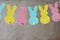 Garland with colorful paper rabbits on gray background. Concept Easter Bunny Banner