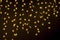 A garland curtain in the form of stars hangs on a dark background.