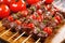 garlic bbq steak tips on a skewer with cherry tomatoes