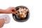 Garlic on black plate, the usual seasoning. Woman puts garlic on a plate from a plastic bag, isolated. Horizontal photo, flu