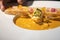 Garlic Bread with Creamy TomYamKung Soup on white dish in studio light, decorated with flower petal on it