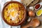 Garlic and bread soup Castilian, from Spain in clay pot and its main ingredients. View from above. Wood background