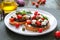 Garlic bruschetta with eggplant, feta, cherry tomatoes, capers. Useful vegetarian appetizer. Italian Cuisine