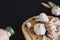 Garlic bulbs on wooden board on black background, with dried garlic and bay leaves. Condiments and spices in kitchen.