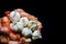 Garlic cloves and bulbs in string bag. Isolated on black background . White onions of garlic in net sack bought in greengrocer`s