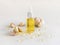 Garlic oil in a bottle and capsules near whole bulb and cloves on a white table close up