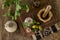 Garlic, parsley and green olives on table with stone mortar. top view