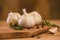 Garlic with rosemary and thyme and spices on a wooden background