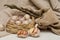 Garlic solo in a wicker basket on a linen background.next to it is a canvas bag