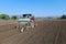 Garlic sowing by tractor, the process of planting garlic cloves in the field. The concept of spring or autumn farming