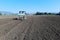 Garlic sowing by tractor, the process of planting garlic cloves in the field. The concept of spring or autumn farming