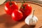 Garlic and three bright tomatoes with water drops