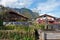 Garmisch-Partenkirchen, old water well, alpin houses, wooden balcony, blooming flowers in summer garden,  mountains, Upper Bavaria