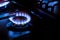 Gas burner with blue burnig methane flame on dark background