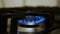 Gas burner. Gas source, a flame burns on a gas stove, blue flames on a black background - with copy space. Blue fire