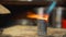 Gas flame flow softens the metal on a wooden table close up