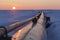 Gas pipelines, crane and pipes for gas and oil transportation, gas processing plant, against the backdrop of sunset