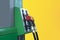 Gas station close-up with colored fuel hoses isolated on yellow background.