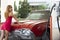 Gas station girl. Woman refuel the car. American red retro automobile.