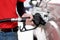 Gas station worker in red uniform filling up bronze pickup truck tank. Closeup hand holding black gas pump nozzle