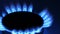 Gas stove burner closeup, blue gas flame in the dark