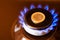 gas stove burner with one euro coin laid on top, burning natural gas with blue flame