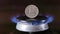 gas stove burner with russian ruble standing vertically on top, burning natural gas with blue flame