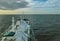 Gascarrier sailing close to coastline with wind power plant and cloudy sky background