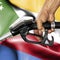 Gasoline consumption concept - Hand holding hose against flag of Comoros