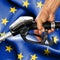 Gasoline consumption concept - Hand holding hose against flag of European Union