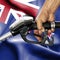 Gasoline consumption concept - Hand holding hose against flag of New Zealand