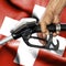 Gasoline consumption concept - Hand holding hose against flag of Switzerland