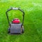 Gasoline lawn mower on green grass.Backyard lawn care equipment