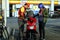 Gasoline station employee refills the fuel tank of a motorcycle for a customer