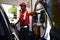 Gasoline station employee serves a customer and refills the gas tank a vehicle