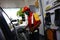 Gasoline station employee serves a customer and refills the gas tank a vehicle