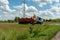 A gasoline tank truck with an orange petrol tank lorry and with an inscription in Russian - Dangerous, stands on the roadside in a