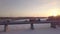 Gasoline truck moving along bridge over frozen river against winter landscape