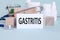 GASTRITIS - text on card on wooden table with stethoscope  medical pills and wooden blocks