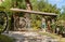 Gate decorated with old wooden wheel and bronze statues in a rural house