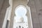 Gate and domes of White Grand Mosque built with white marble stone, also called Sheikh Zayed Grand Mosque, inspired by Persian,